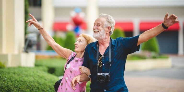 Elderly Couple Holding Hands While Walking Outdoors At Assisted Living Facility