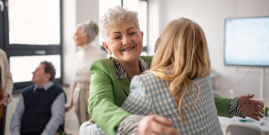 Elderly Woman Hugging Family Member at Assisted Living Facility