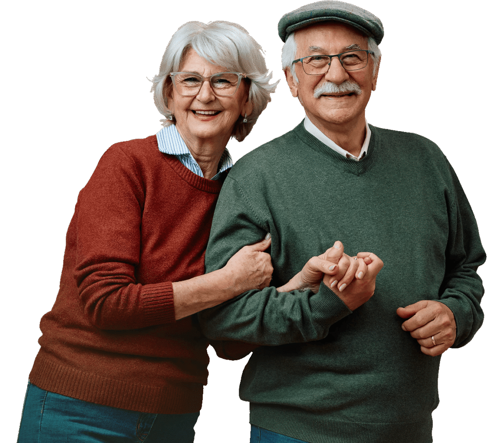Smiling Elderly Couple in Sweaters Posing Arm in Arm at an Independent Living Community Smiling Elderly Couple in Sweaters Posing Arm in Arm at an Independent Living Community