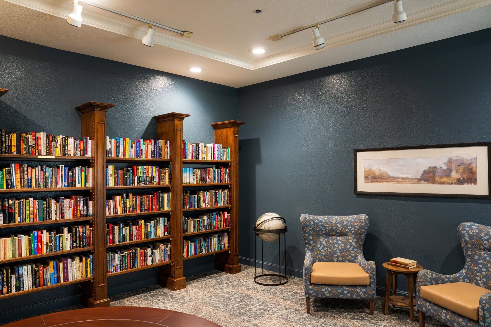 Cozy Library With Bookshelves and Armchairs in an Assisted Living Facility