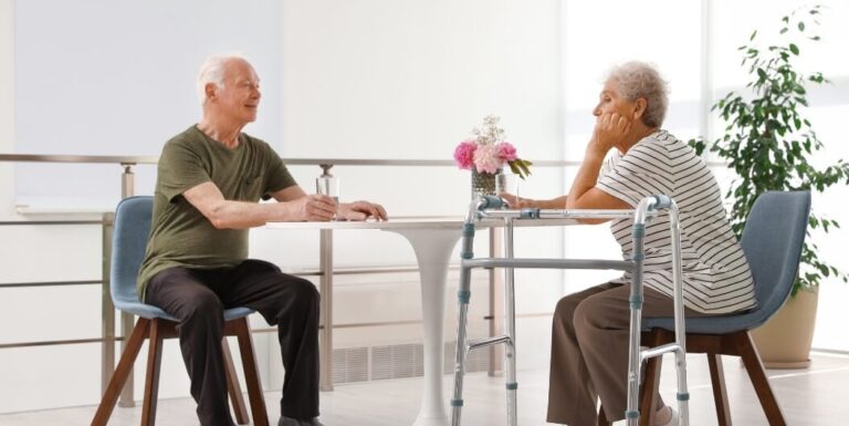 Elderly Couple Seated Together near Window at Independent Living Facility