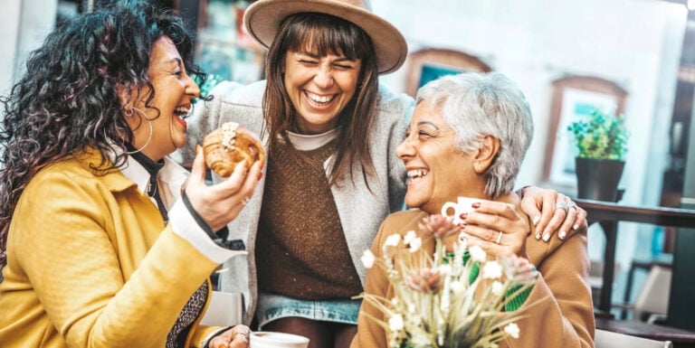 Elderly Friends Laughing Together over Coffee at Assisted Living Facility